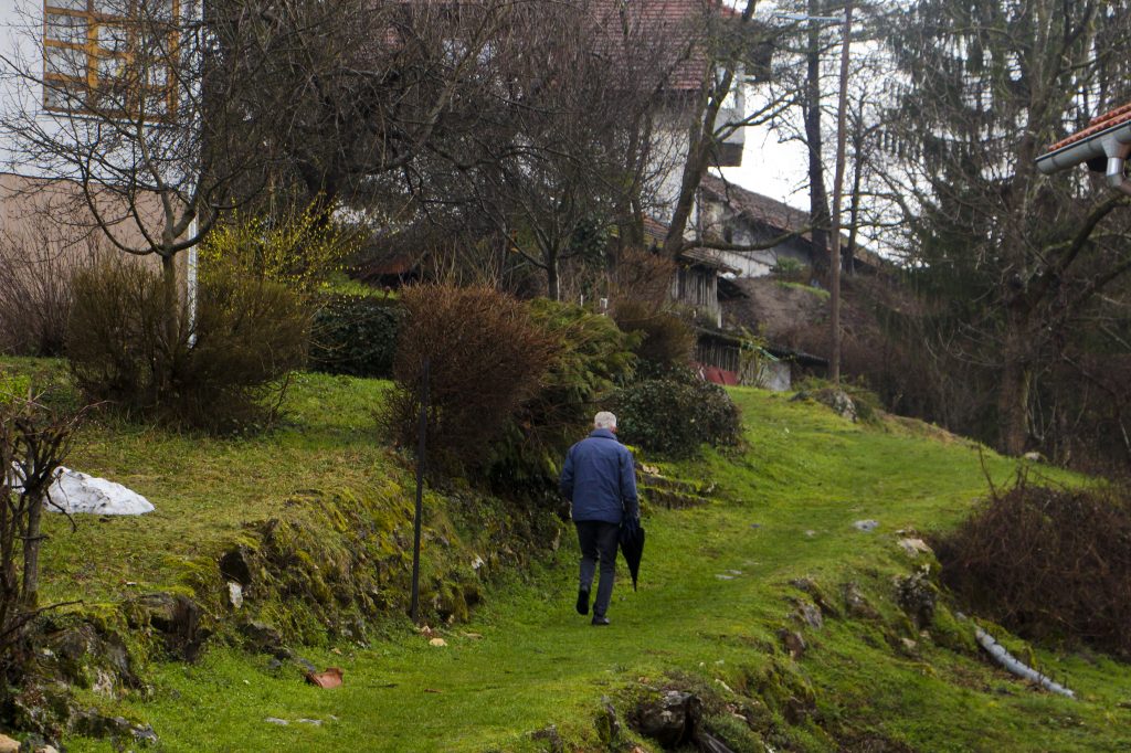 An older man walks up a moss covered path in the mill village of Rastoke (Slunj), Croatia